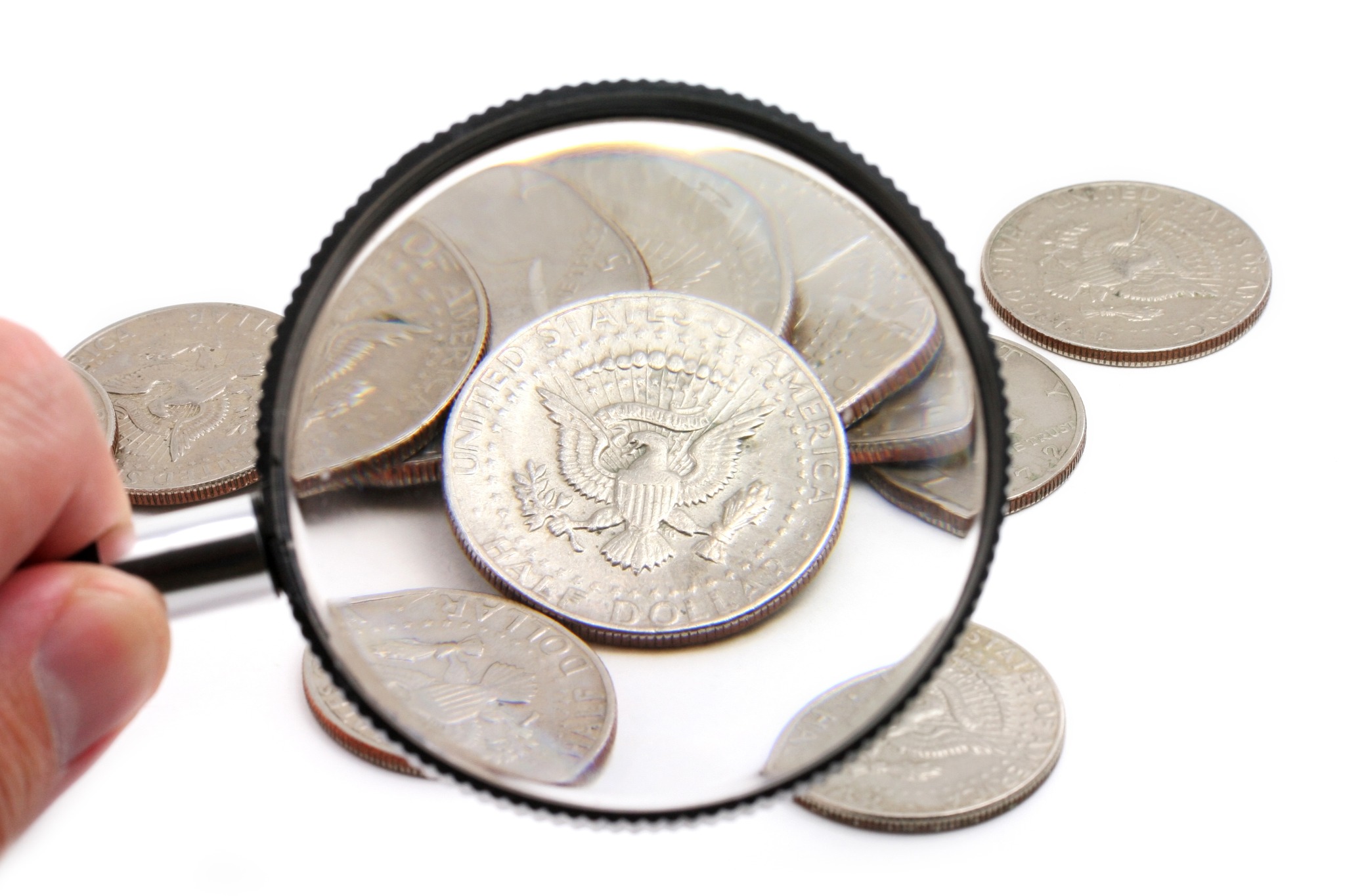 Coins examined beneath a magnifying glass