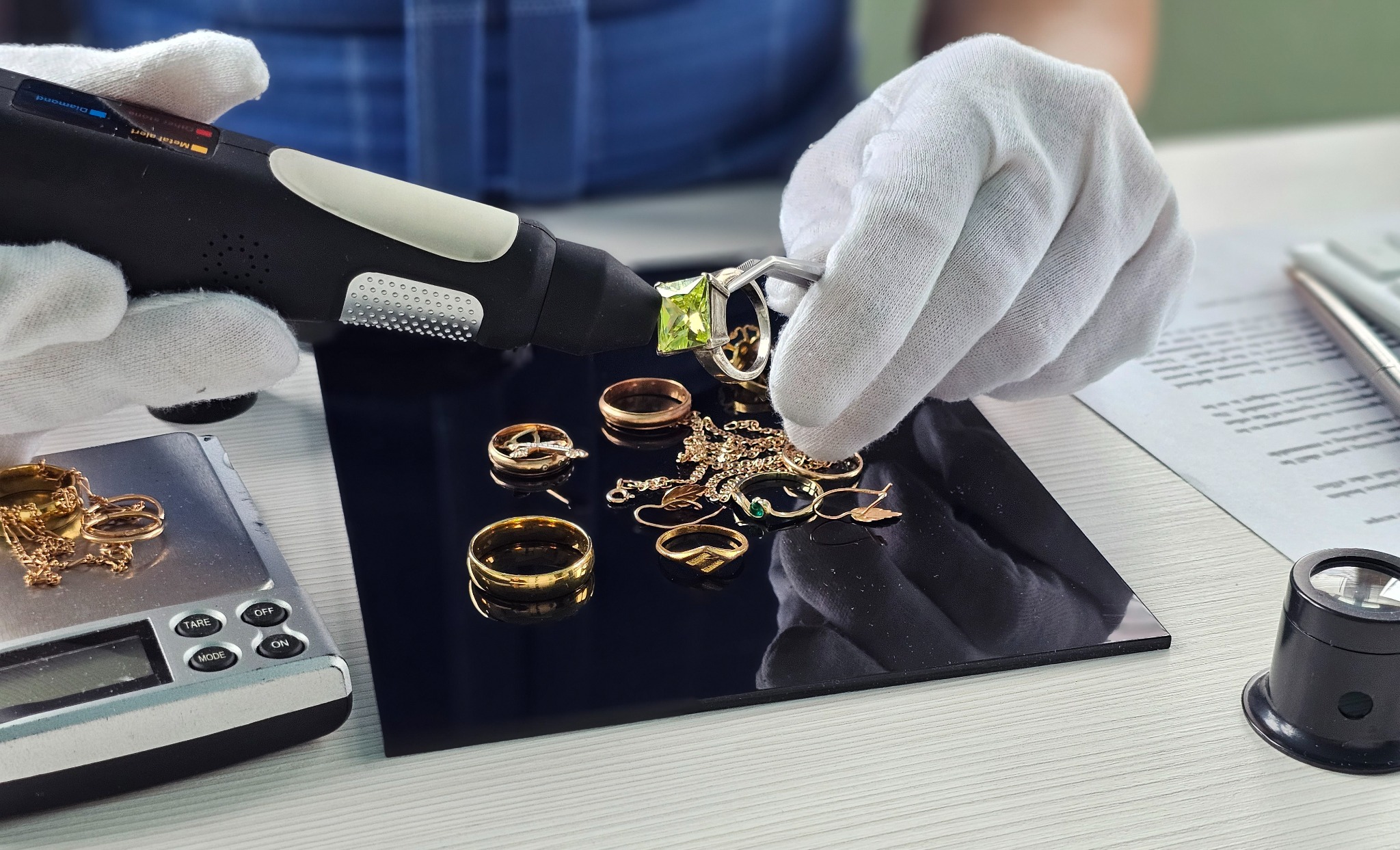 Jewelry being examined with gloves and a material testing instrument