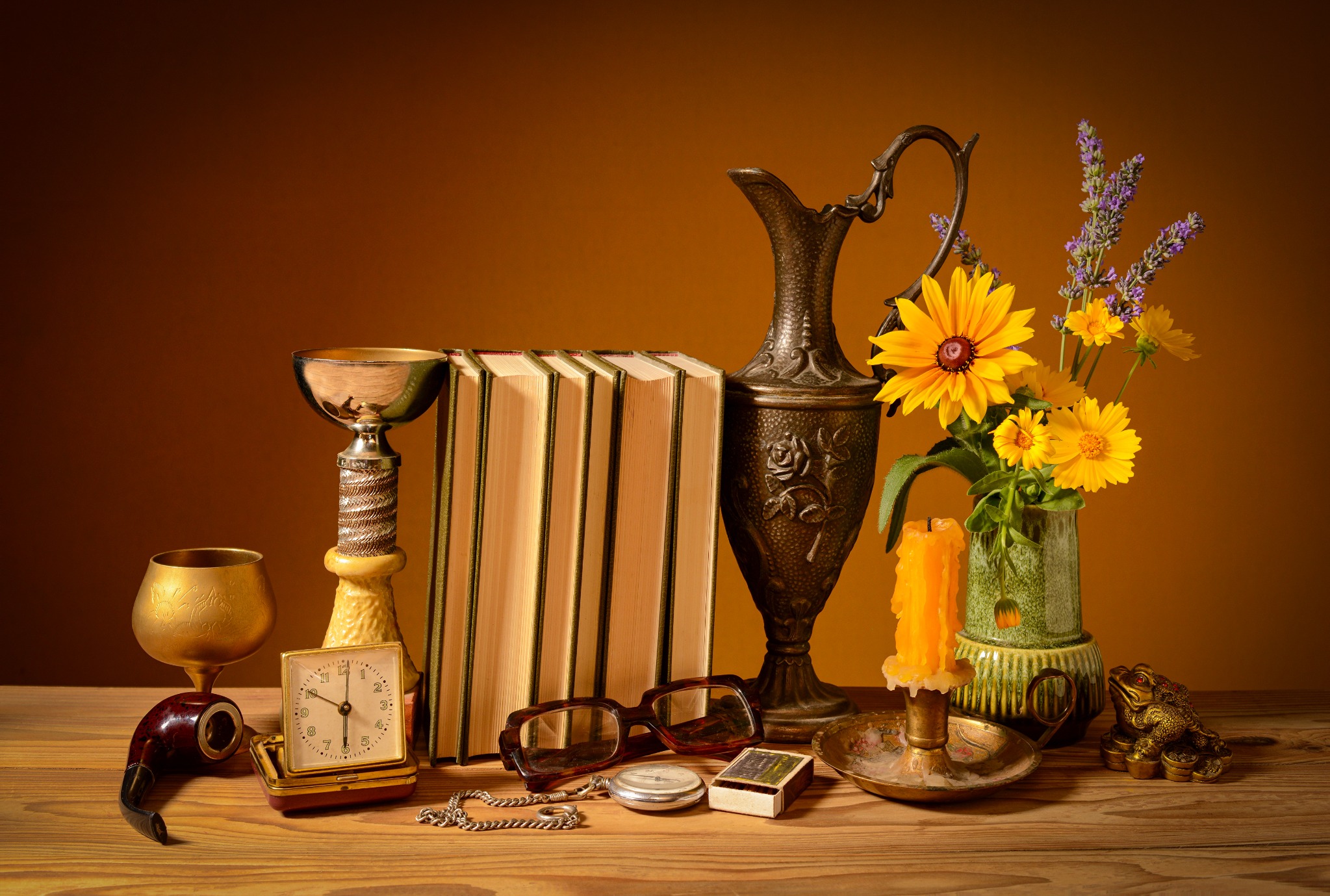 A warm still life of books, flowers, and collected vintage objects